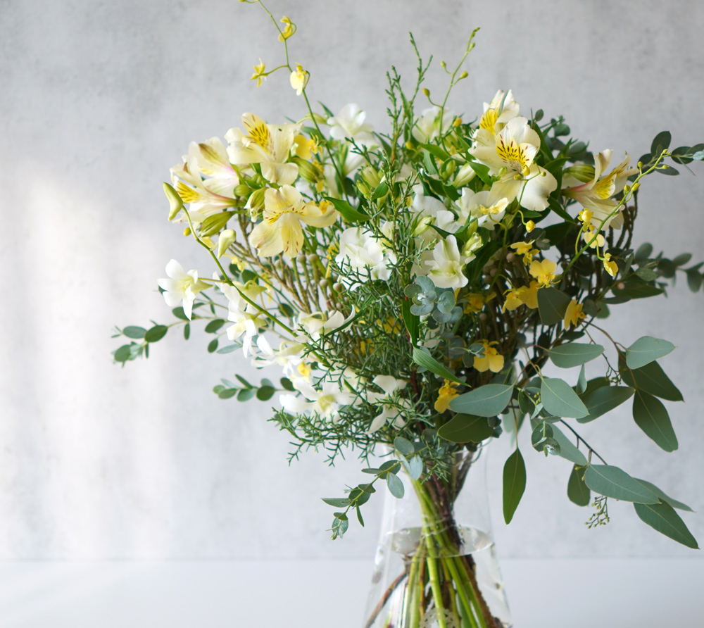 【クリスマス】白や淡い黄色の花々に、季節感のあるリーフを合わせた花束