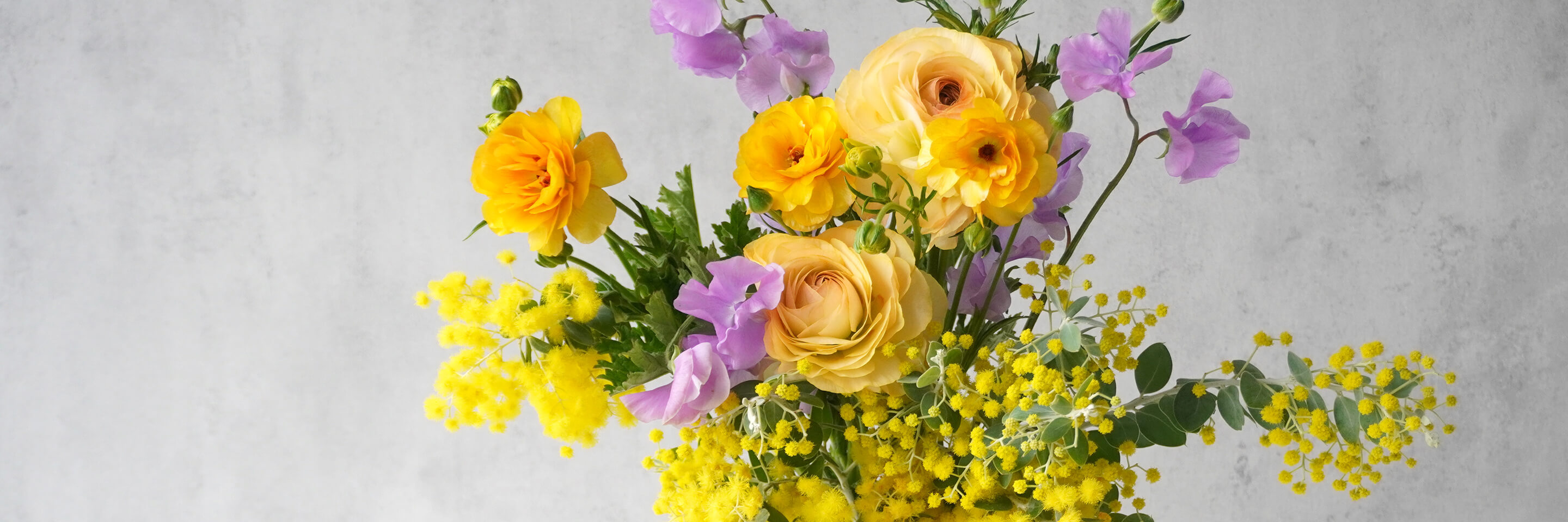 オレンジのラナンキュラスとミモザの花瓶活け