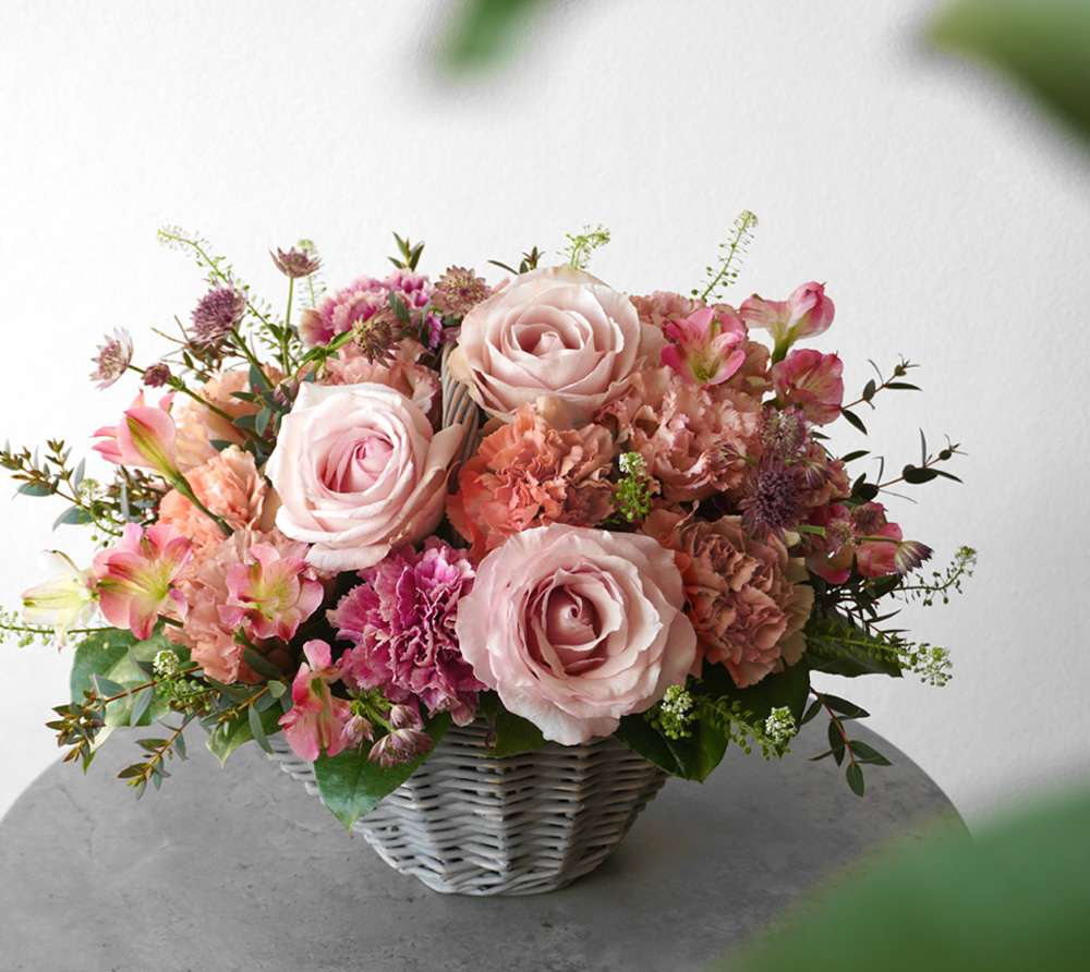 淡いピンクのバラとアプリコットのカーネーションのアレンジメント