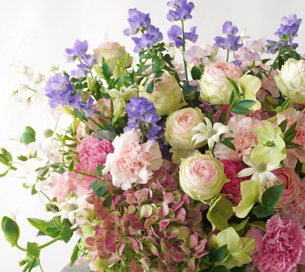 【母の日】淡いピンクから淡いグリーンへ広がるバラとカーネーションのアレンジメント