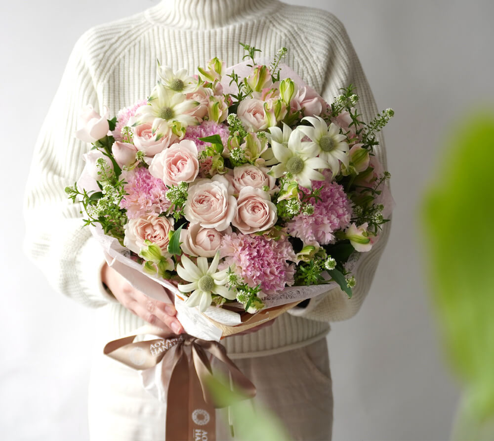 淡いピンクのスプレーバラやカーネーションの花束