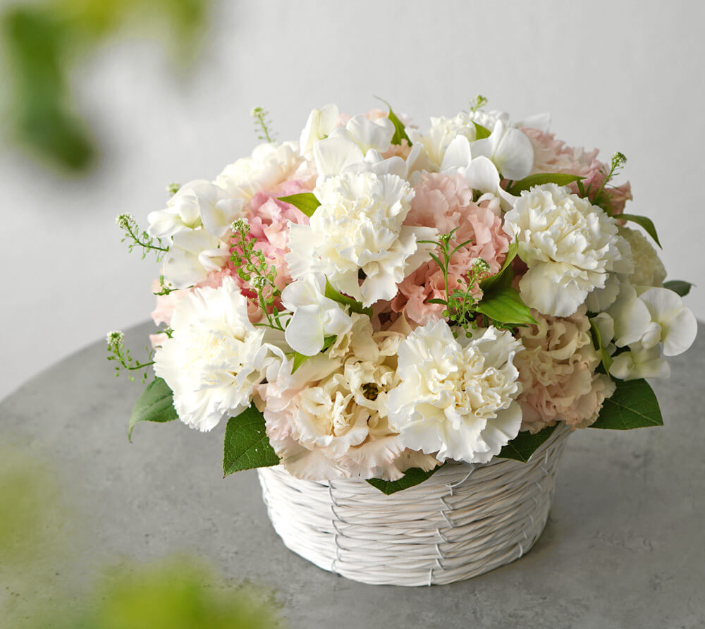 白いカーネーション、淡いピンクのトルコキキョウのお供えアレンジメント