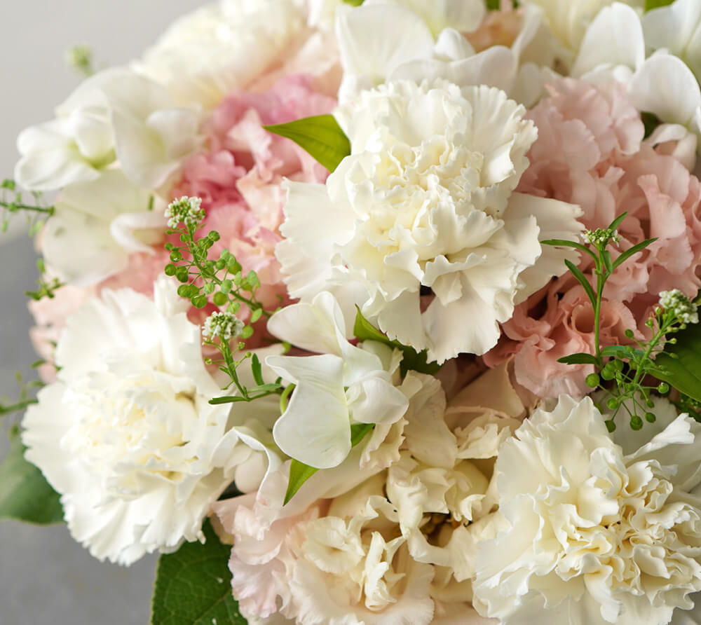 白いカーネーション、淡いピンクのトルコキキョウのお供えアレンジメント