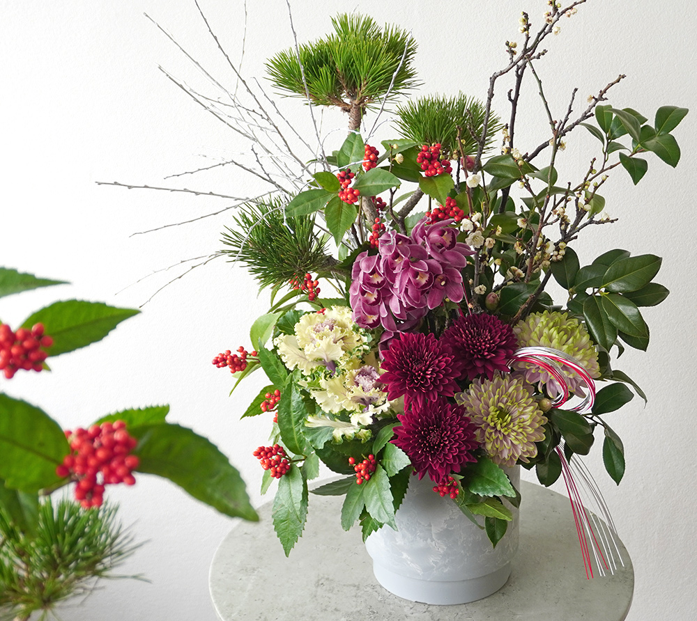 三光松やピンクのシンビジュームや赤いマムのアレンジメント