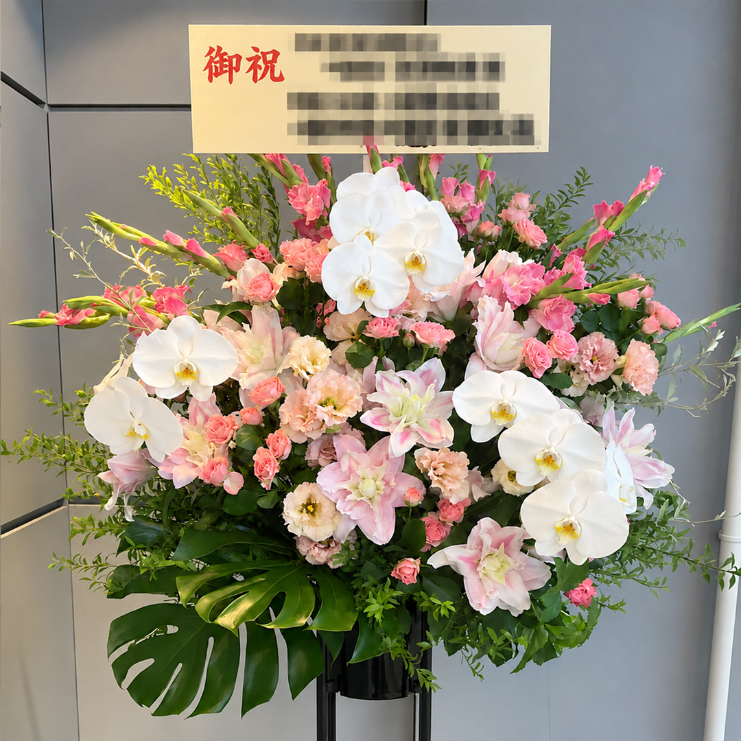 白とピンクの華やかな花々でまとめられたスタンド花