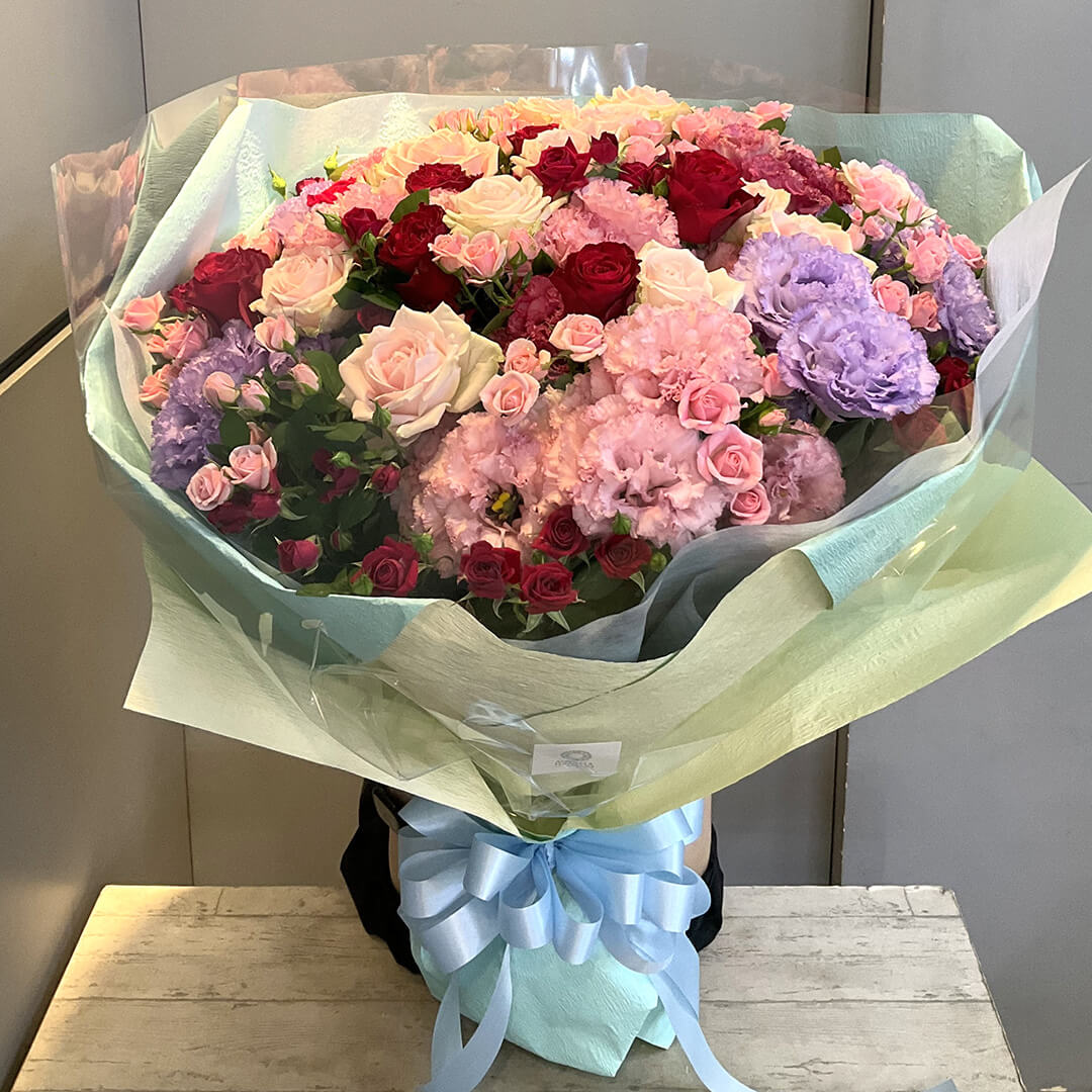 ピンクバラをメインに赤バラやパープルの花をあしらった花束