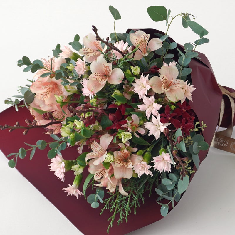 【クリスマス】ピンクや赤の花々に、季節感のあるリーフを合わせた花束