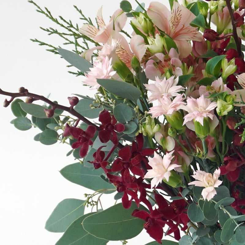 【クリスマス】ピンクや赤の花々に、季節感のあるリーフを合わせた花束