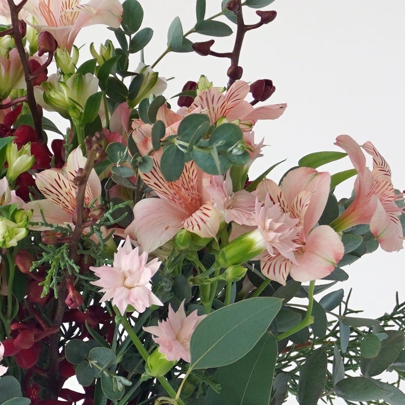 【クリスマス】ピンクや赤の花々に、季節感のあるリーフを合わせた花束